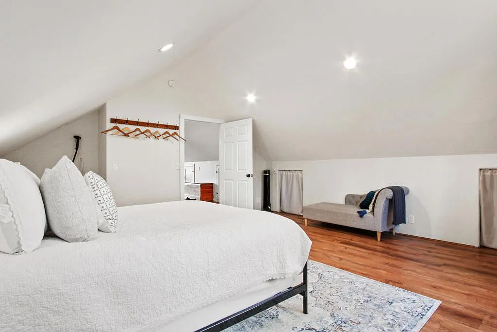 Upper bedroom with a vaulted ceiling and a chaise longue