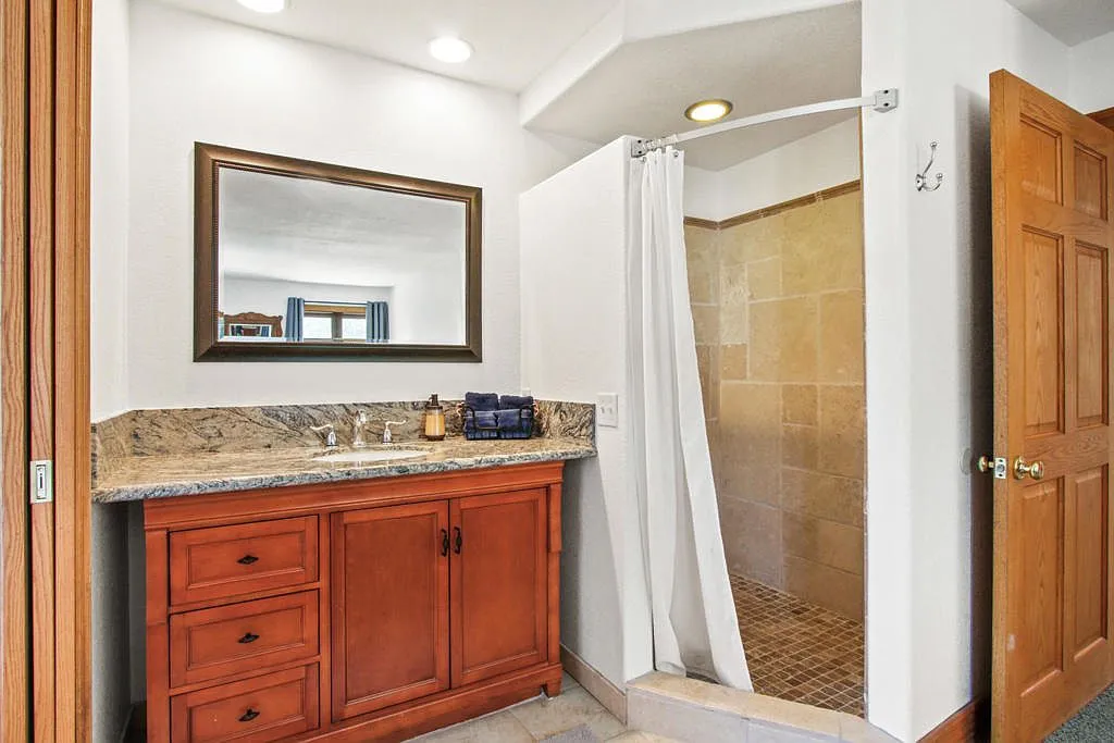 Bathroom with a granite topped vanity and walk in shower