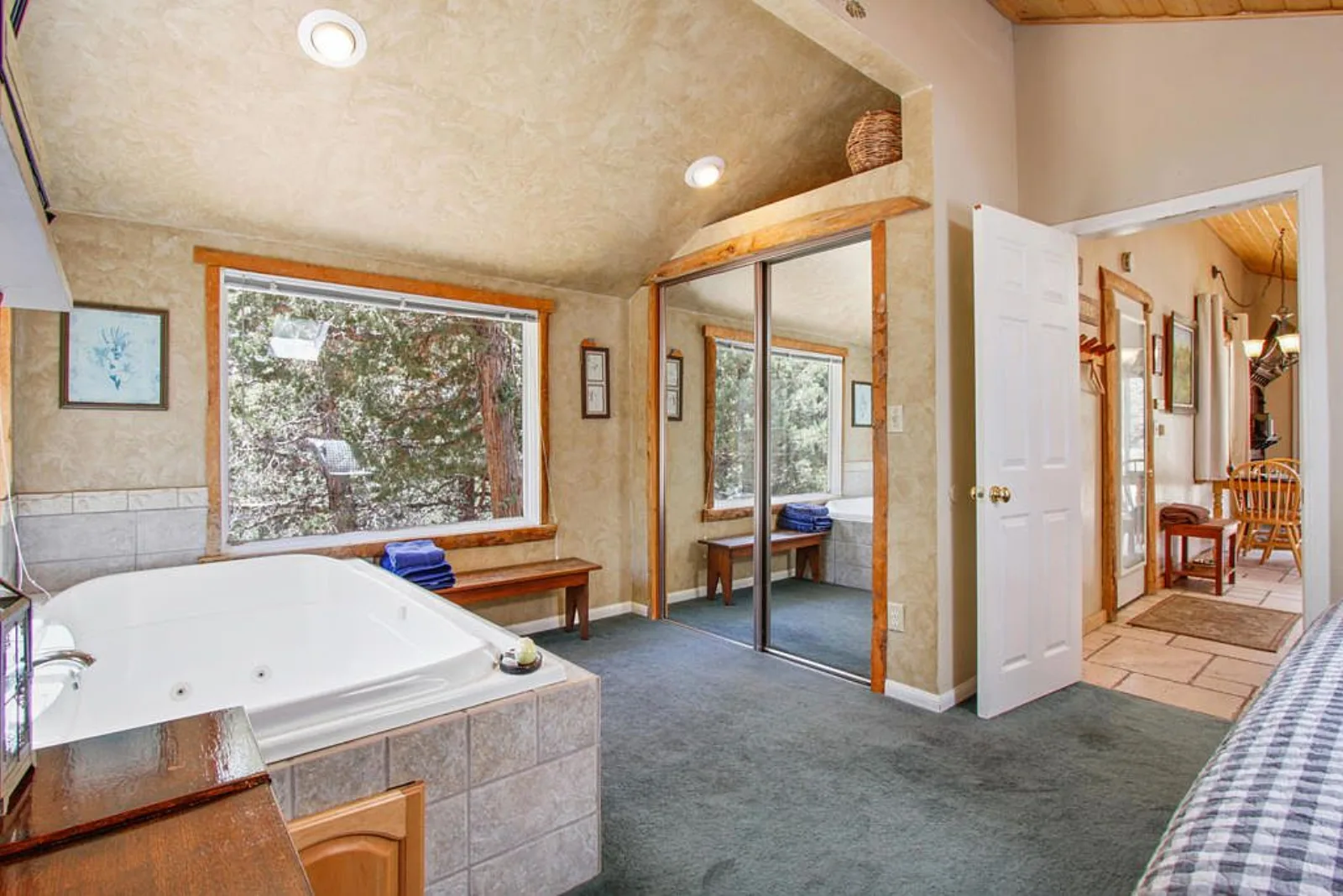 Jetted tub area with mirrored closet doors