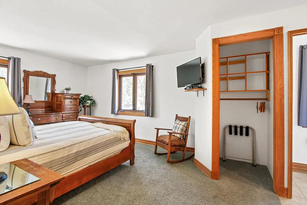 Bedroom with a sleigh bed, dresser and open closet nook