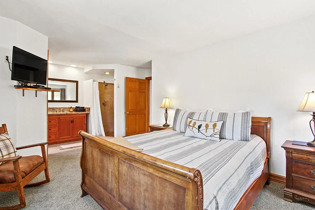 Bedroom with a sleigh bed looking through to the ensuite