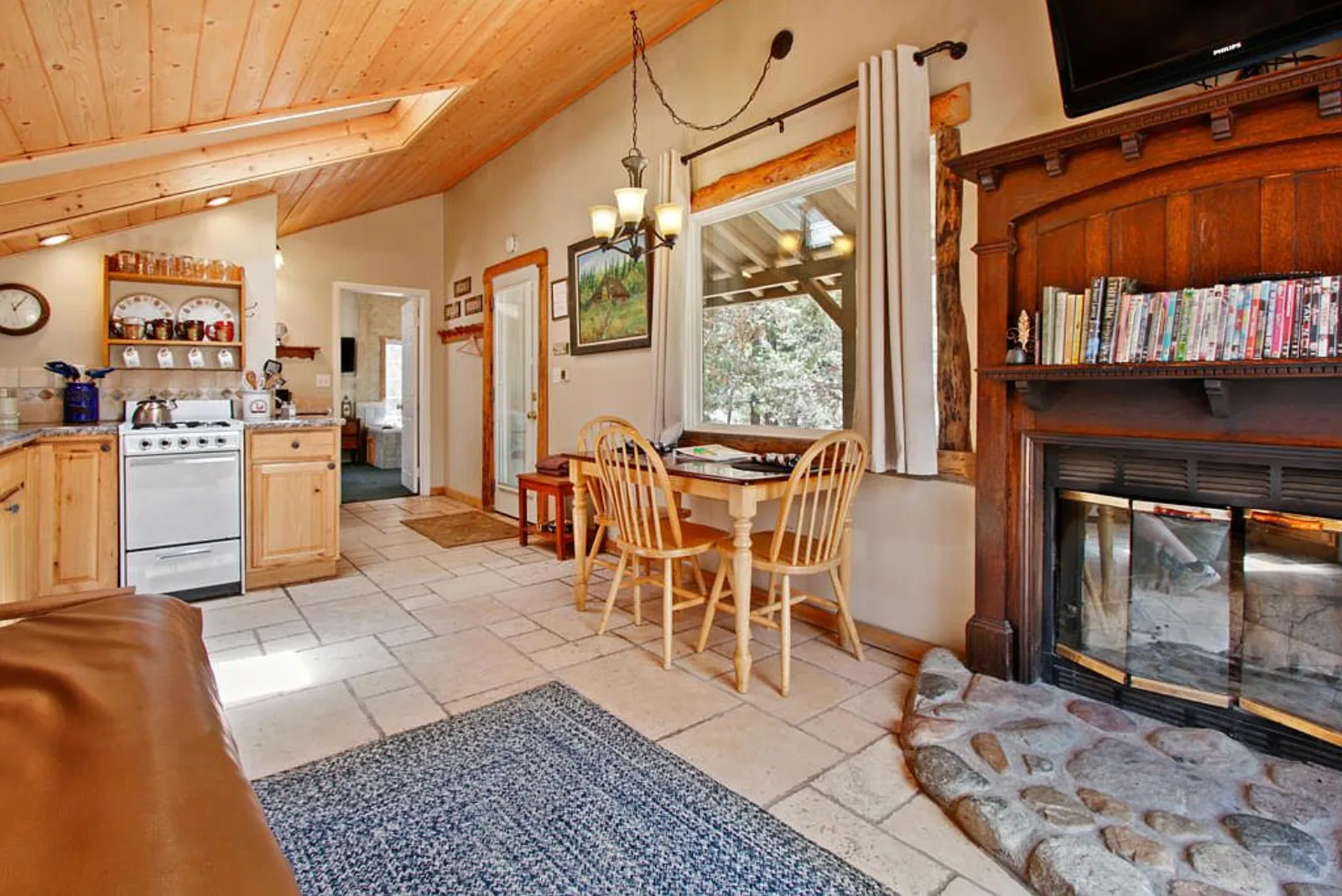 Cabin dining area beside the fireplace under a wood ceiling