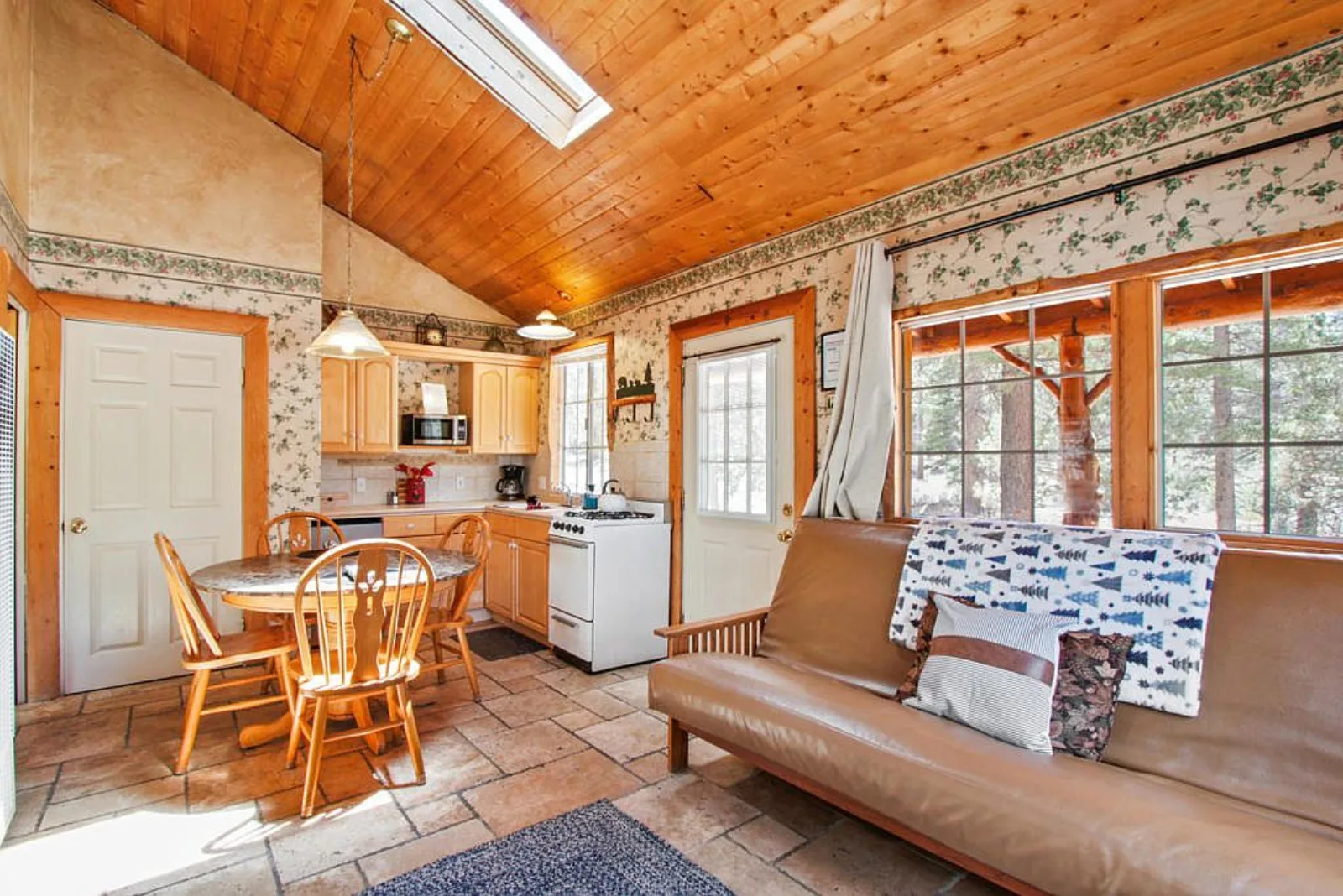 Cabin great room with its own kitchen, dining table and leather futon