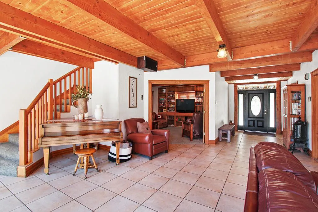 Entry with the grand piano, staircase and den beyond