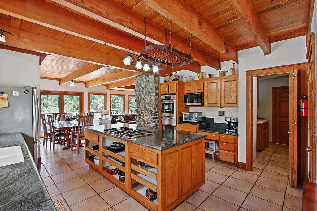 Lodge kitchen with oak cabinetry, a centre island and beamed ceiling