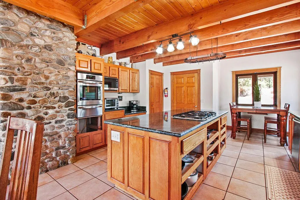 Lodge kitchen with a stone accent wall and double wall ovens