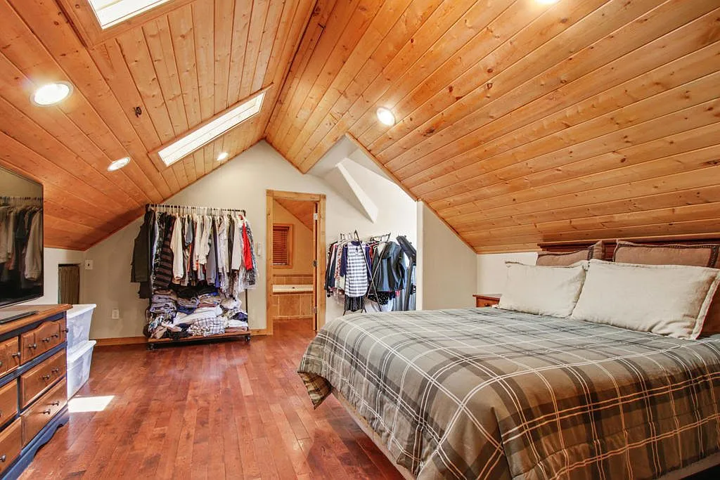 Loft bedroom with skylights and open clothing racks