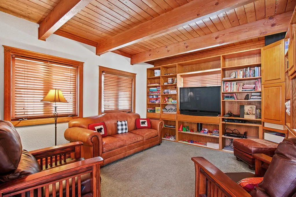 Den with leather sofas and built in bookshelves