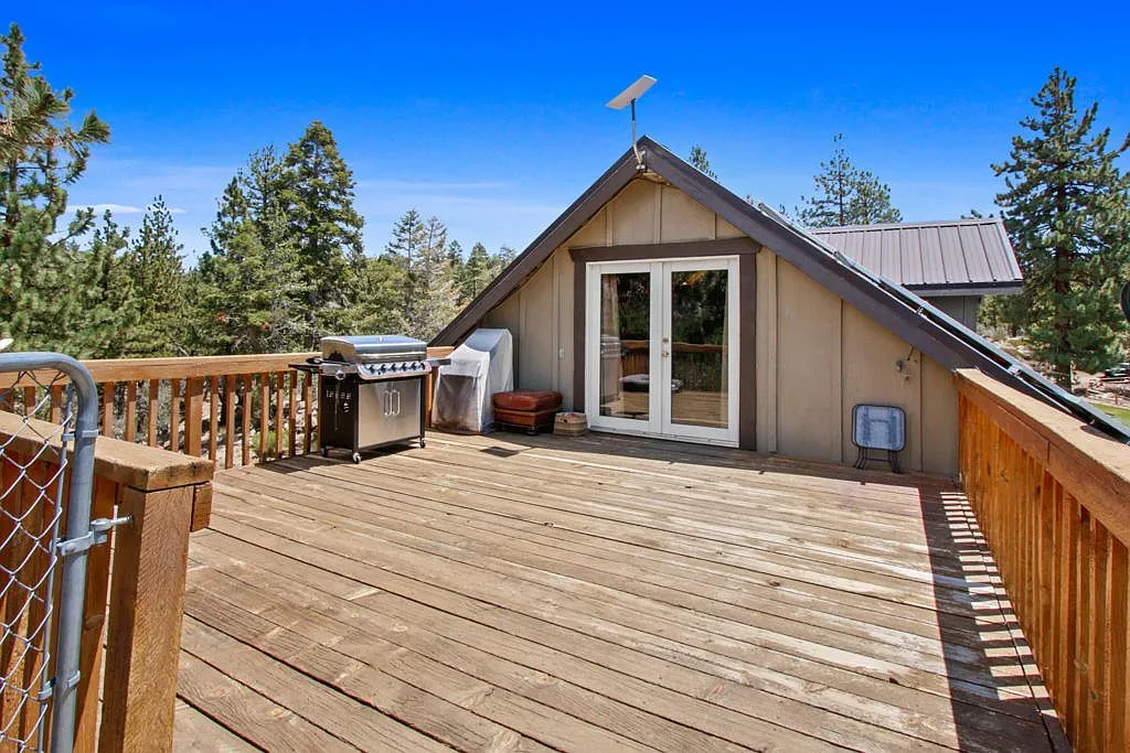 Rooftop wood deck with a grill, opening off the upper level