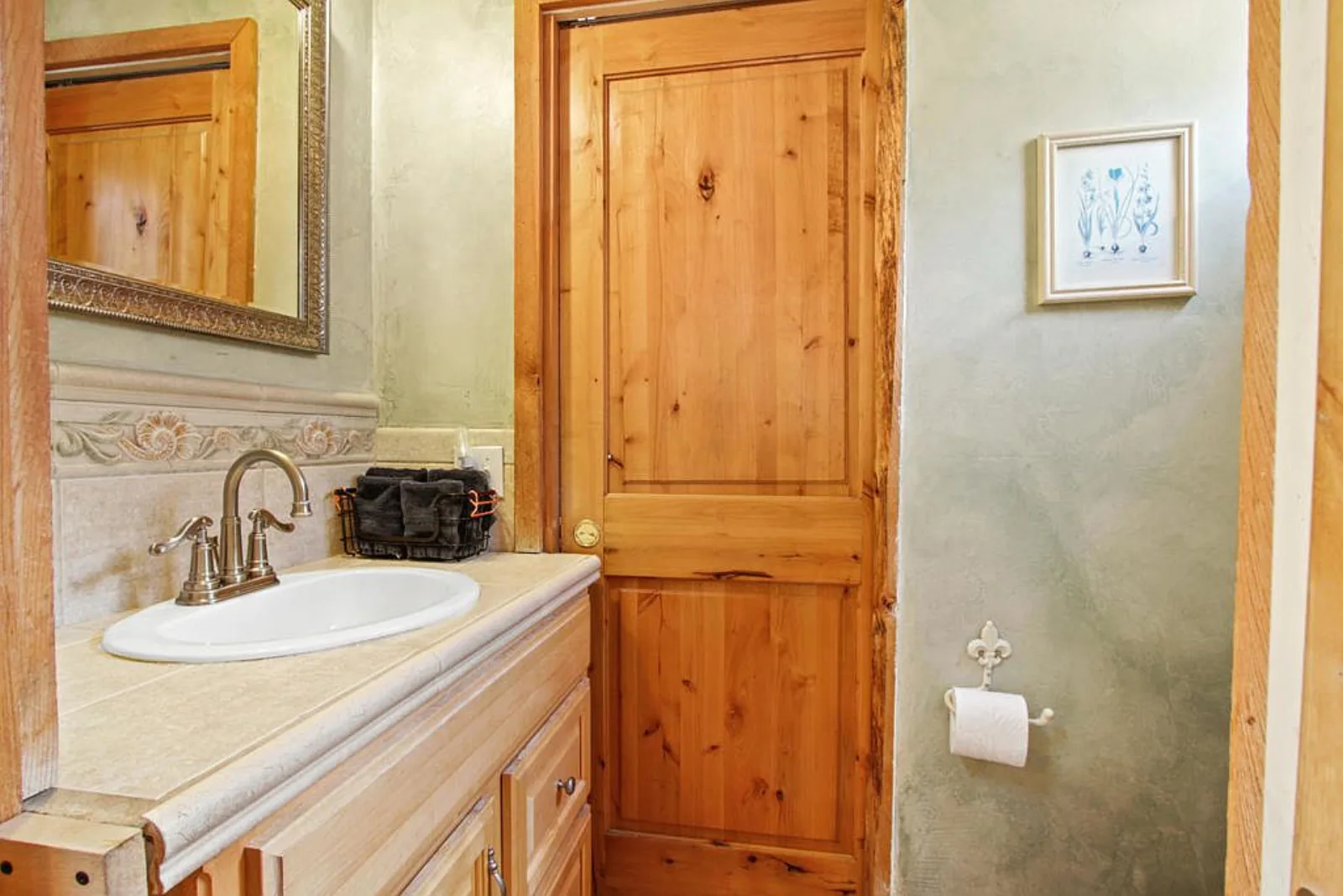 Small bathroom with a light wood vanity and tile backsplash